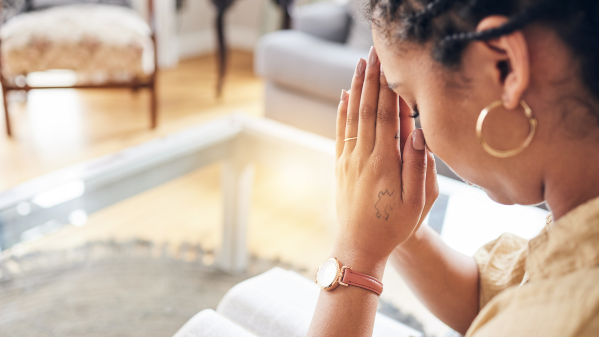 Mujer orando con una biblia.