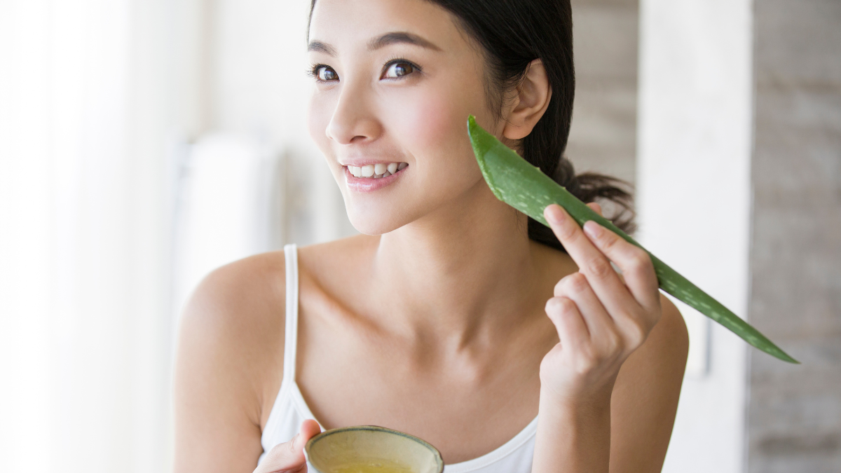 Mujer aplicándose aloe vera en el rostro.