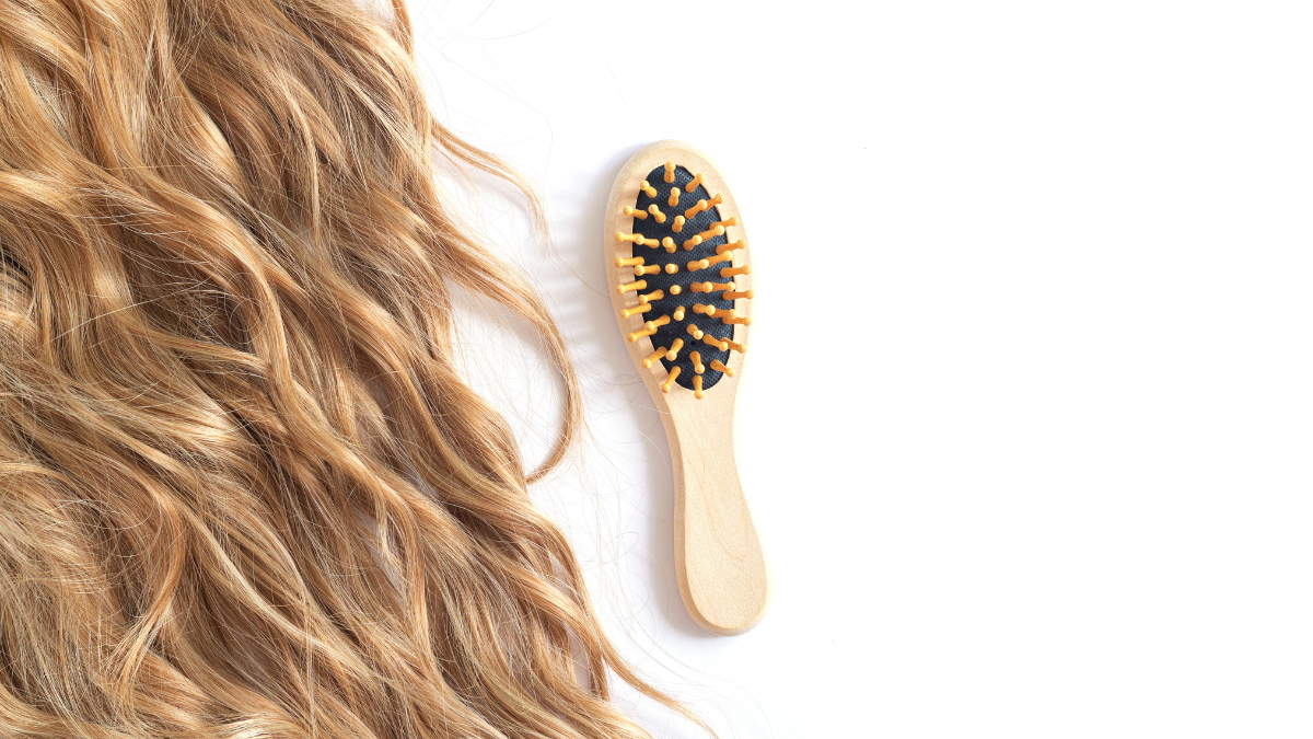 Cabello ondulado y al lado un cepillo para el cabello.