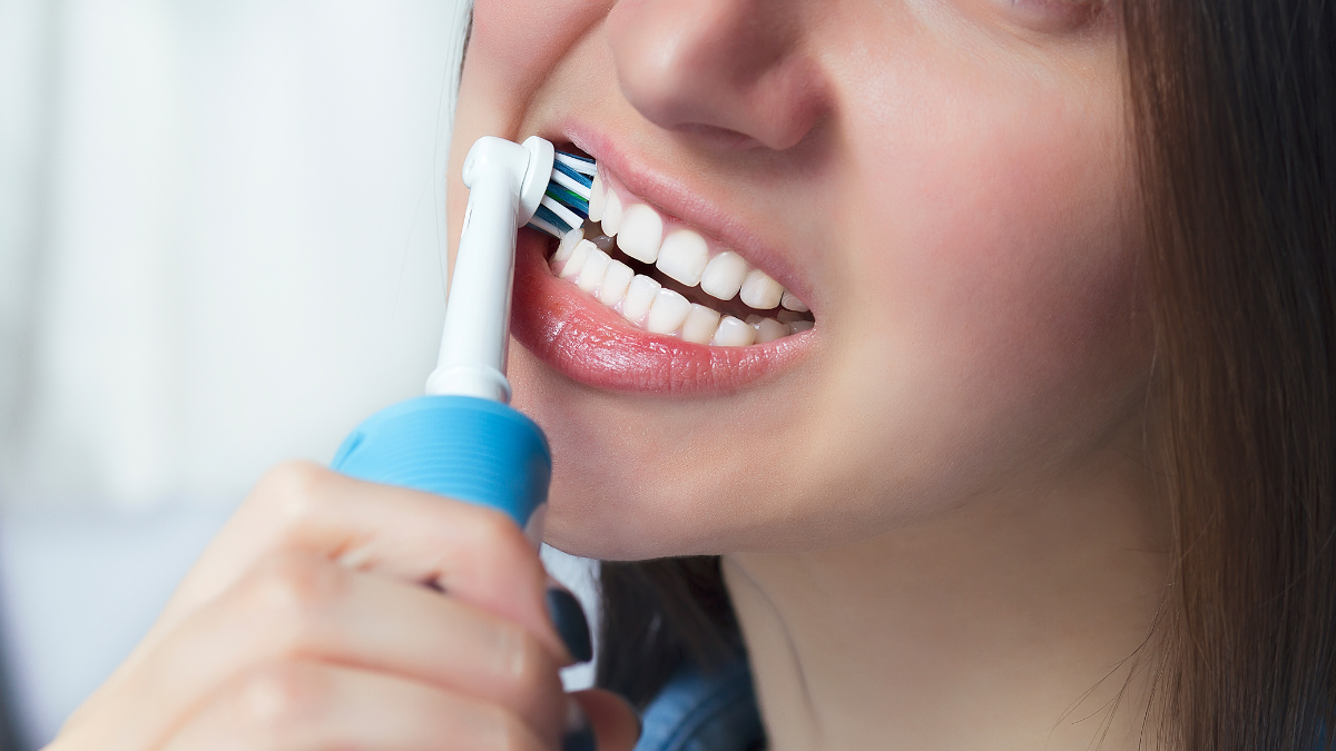 Mujer cepillándose los dientes.