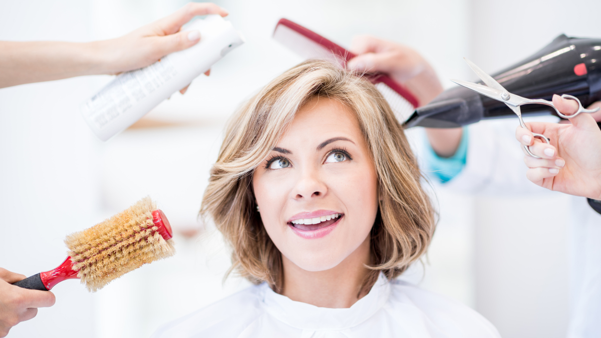 Mujer en la peluquería con implementos para peinar alrededor.