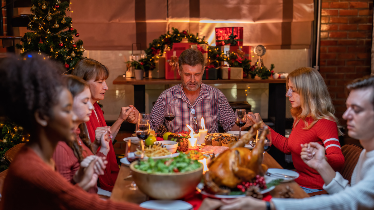 Familia orando en la cena de Navidad.