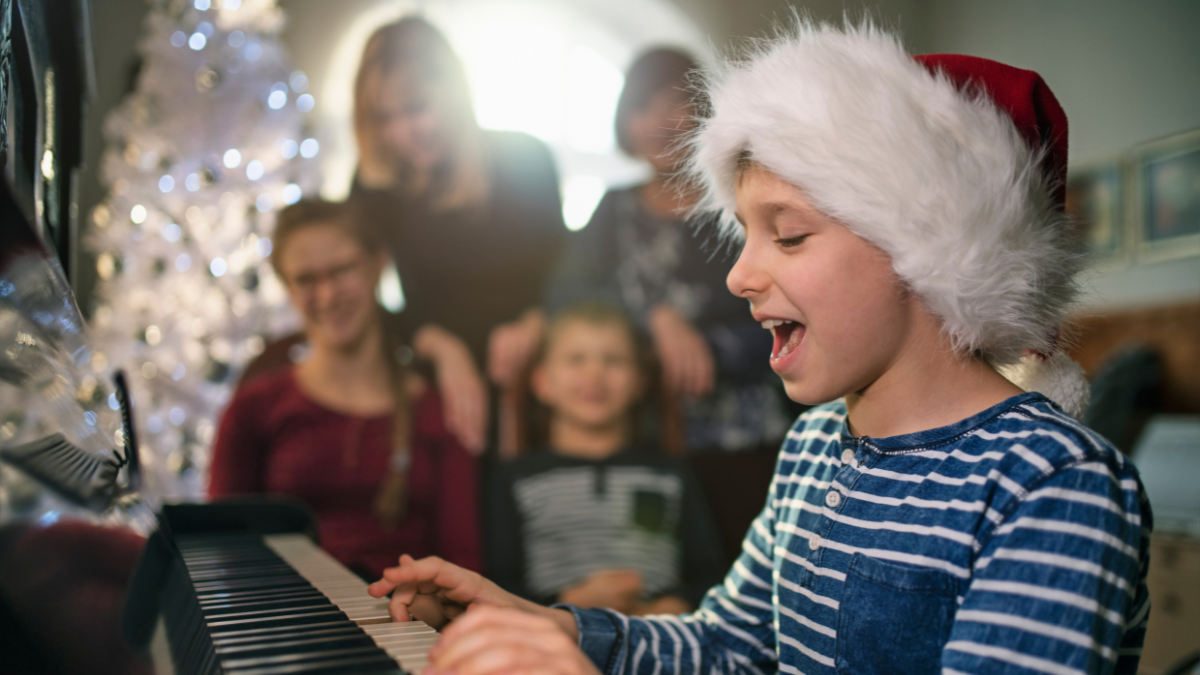 Niño cantando a su familia en Navidad.