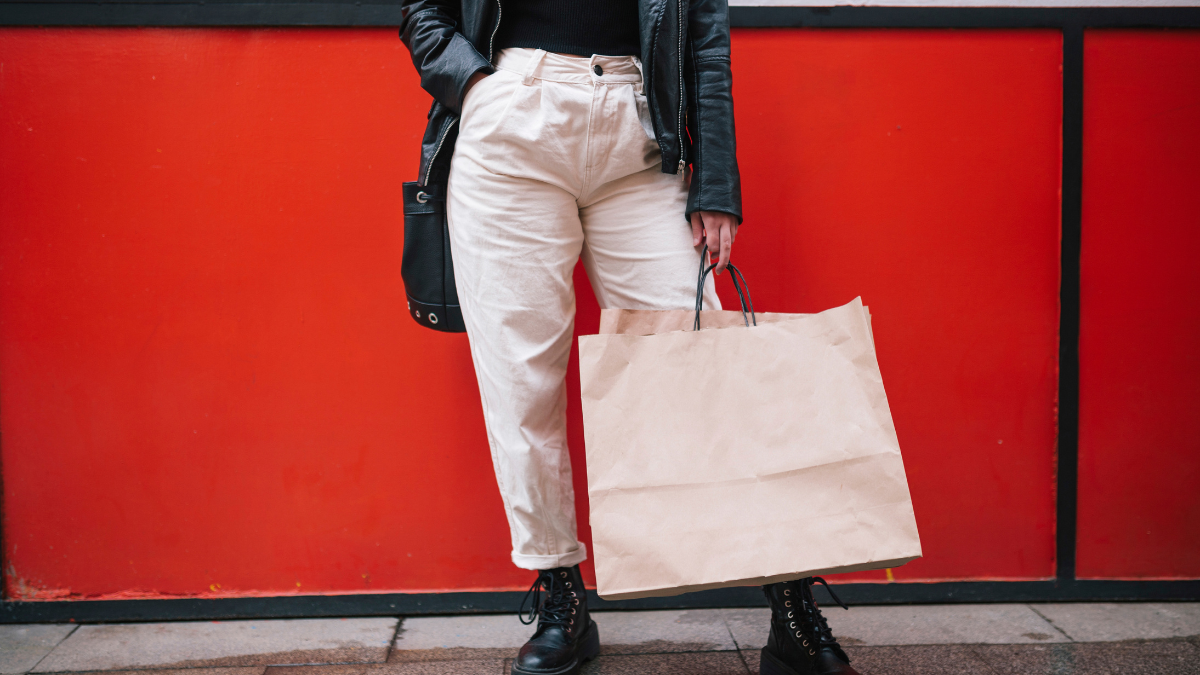 Persona posando con una bolsa de compras.